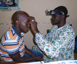 Un oftalmólogo revisa los ojos a un paciente en Mali 