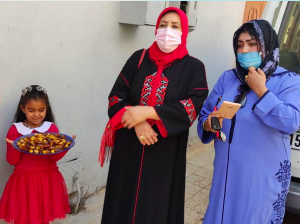 Two women and a girl with a plate of sweets.