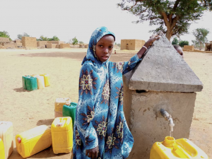 Niña recogiendo agua en una fuente