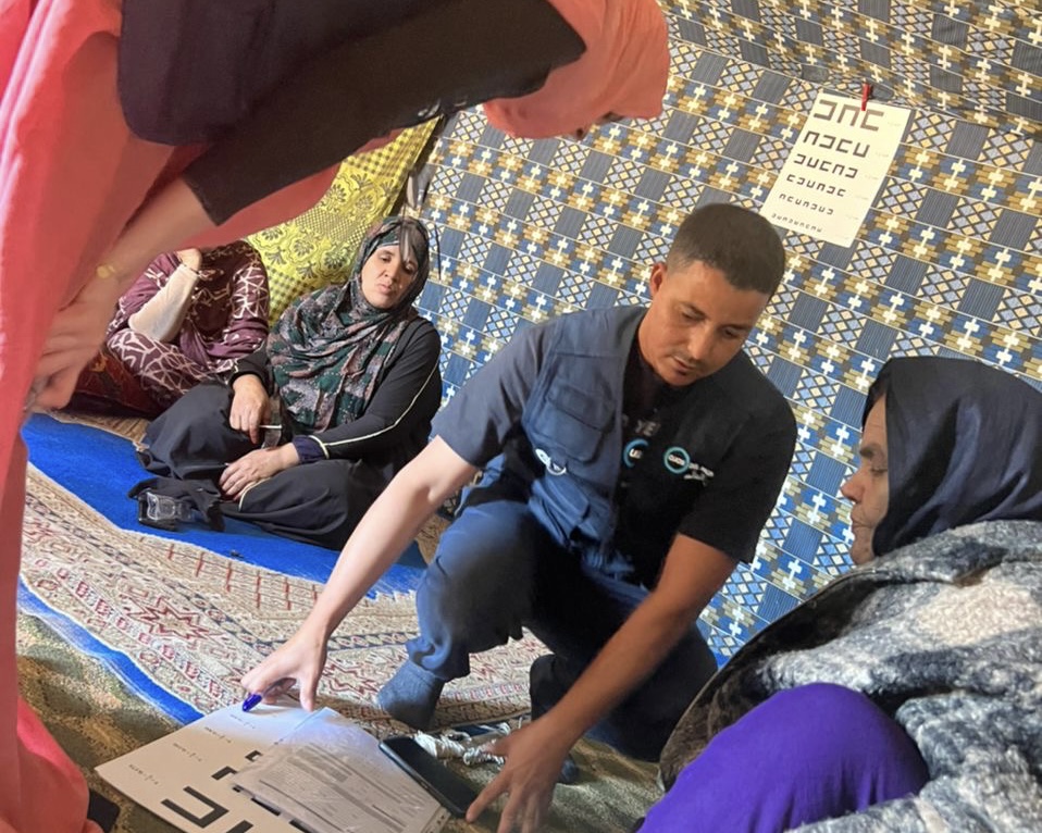 Ophthalmology technician attending to a woman in a haima. Ophthalmology technician attending to a woman in a haima.