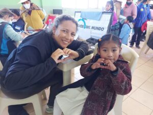 Optometrista y niña haciendo un corazón con las manos