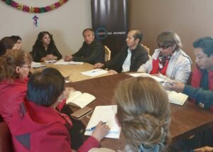 Grupo de mujeres y hombres sentados en una mesa durante la reunión de balance de 2023