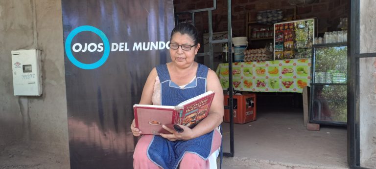 Norma Tejerina reading in front of an Eyes of the world label